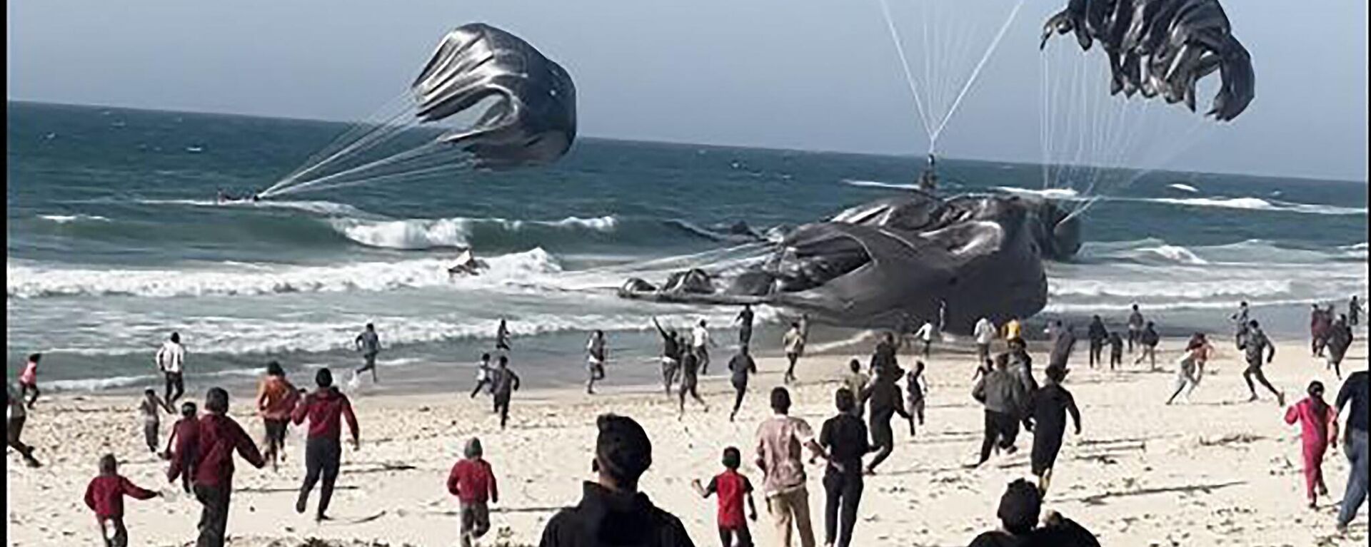  Palestinians running toward parachutes attached to food parcels, airdropped from US aircrafts on a beach in the Gaza Strip on March 2, 2024. - Sputnik International, 1920, 25.03.2024