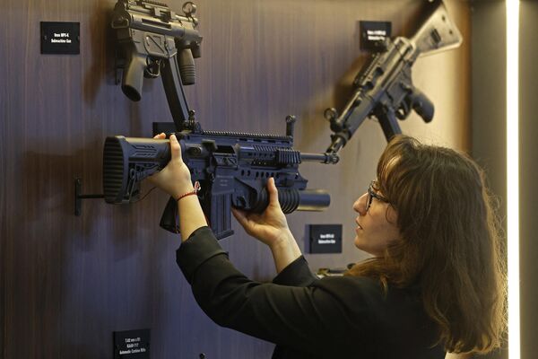 An exhibitor arranges a rifle on display.  - Sputnik International