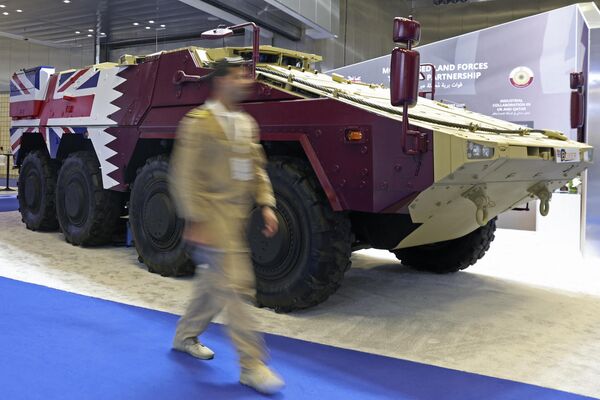 A visitor walks past an armored vehicle on display at Britain&#x27;s pavilion.  - Sputnik International