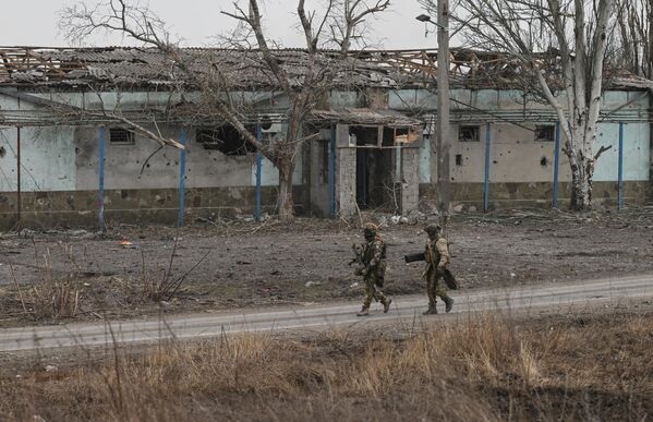 Russian troops inspect an area for possible mines left behind by Ukrainian forces. - Sputnik International