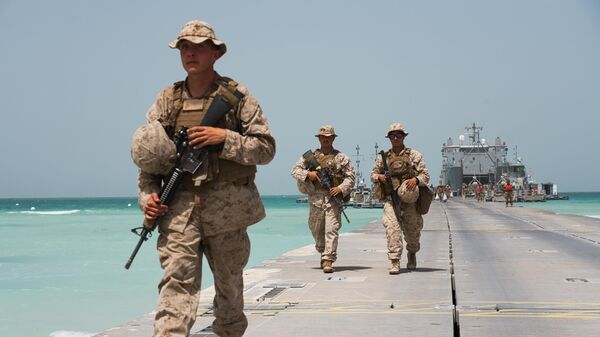 U.S. Marines walk down a removable Trident Pier leading to an American ship docked near an Emirati military base home to a Military Operations and Urban Terrain facility in al-Hamra, United Arab Emirates, Monday, March 23, 2020 - Sputnik International