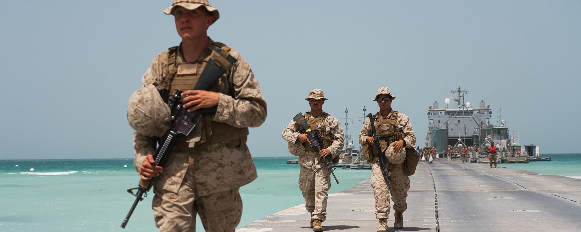 U.S. Marines walk down a removable Trident Pier leading to an American ship docked near an Emirati military base home to a Military Operations and Urban Terrain facility in al-Hamra, United Arab Emirates, Monday, March 23, 2020 - Sputnik International, 1920, 10.04.2024