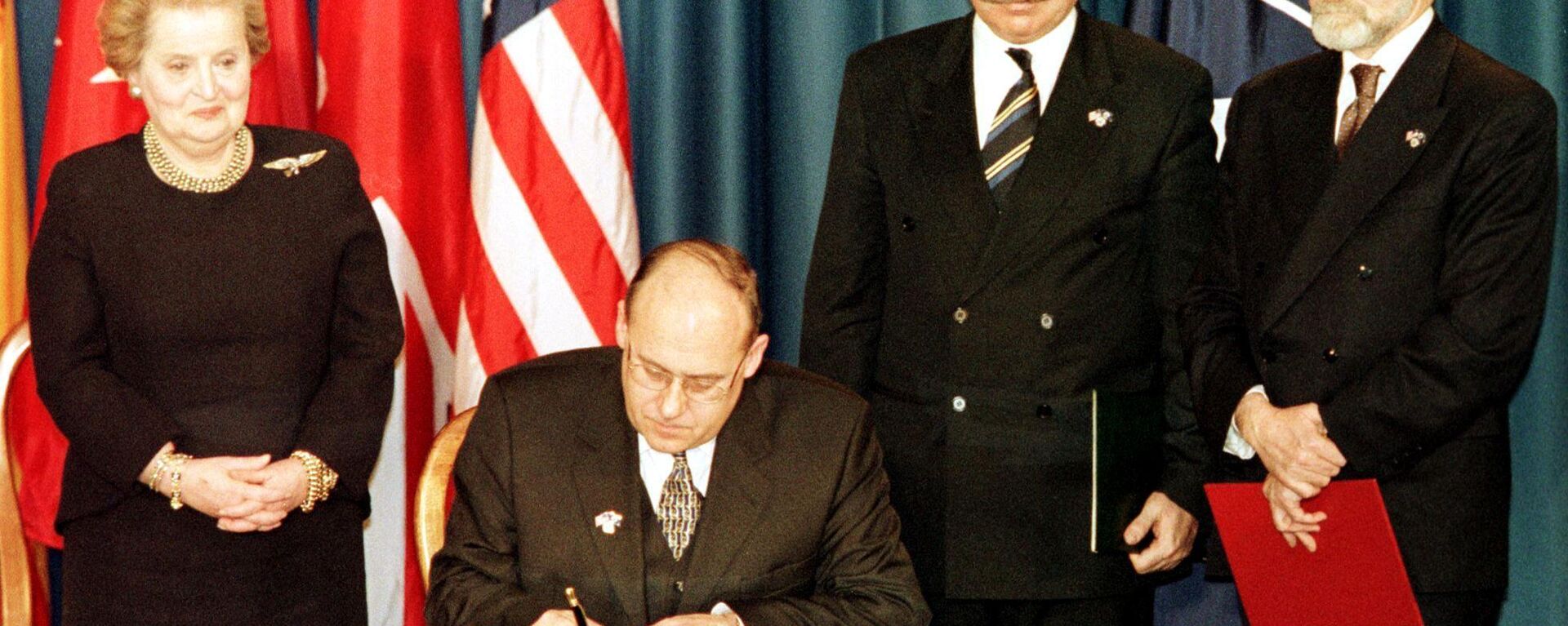 The Minister of Foreign Affairs of the Czech Republic Jan Kavan (seated) signs the accession document that enters the Czech Republic into NATO 12 March 1999 at the Harry Truman library in Independence, MO.  Standing are US Secretary of State Madeleine Albright (L), Minister of Foreign Affairs of Hungary Janos Martonyi (C), and Minister of Foreign Affairs of Poland Bronislaw Geremek (R). - Sputnik International, 1920, 12.03.2024