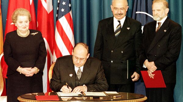 The Minister of Foreign Affairs of the Czech Republic Jan Kavan (seated) signs the accession document that enters the Czech Republic into NATO 12 March 1999 at the Harry Truman library in Independence, MO.  Standing are US Secretary of State Madeleine Albright (L), Minister of Foreign Affairs of Hungary Janos Martonyi (C), and Minister of Foreign Affairs of Poland Bronislaw Geremek (R). - Sputnik International
