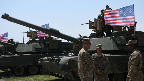 US soldiers stand by Abrams Battle Tanks bearing the US flag ahead of a military drill. File photo. - Sputnik International
