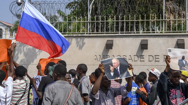 Protesters waving Russian flags and holding a portrait of Russian President Vladimir Putin gather in front of the French Embassy in Kinshasa on March 1, 2023 for a demonstration against the visit to the Democratic Republic of Congo of French President Emmanuel Macron.  - Sputnik International
