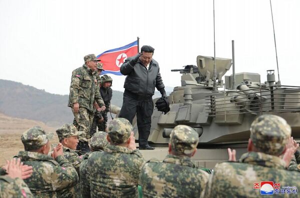 Kim Jong Un stands on a new main battle tank after a training competition. - Sputnik International