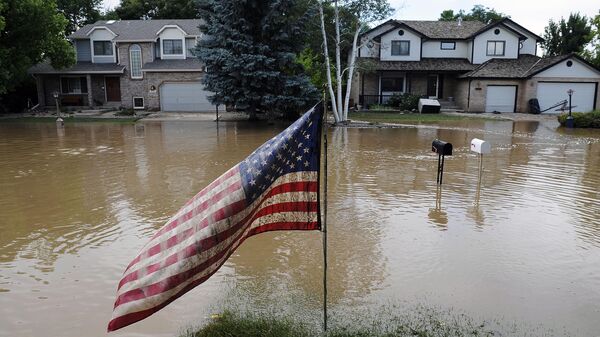 A muddy U.S. flag stands in front of flooded homes in Longmont, Colo., on Saturday, Sept. 14, 2013. Floodwaters have affected a 4,500 square-mile section of the state - Sputnik International