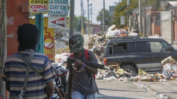 Armed members of the G9 and Family gang stand guard at their roadblock in the Delmas 6 neighborhood of Port-au-Prince - Sputnik International