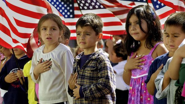 Though some were a bit unsure of the words or exactly where to place your hand over your heart, some of the 700 students at Nevada Avenue Elementary School recite the Pledge of Allegiance, followed by God Bless America, as part of nationwide ceremonies to honor America at 11 a.m. PDT Friday, Oct. 12, 2001, in the Canoga Park district of Los Angeles' San Fernando Valley - Sputnik International