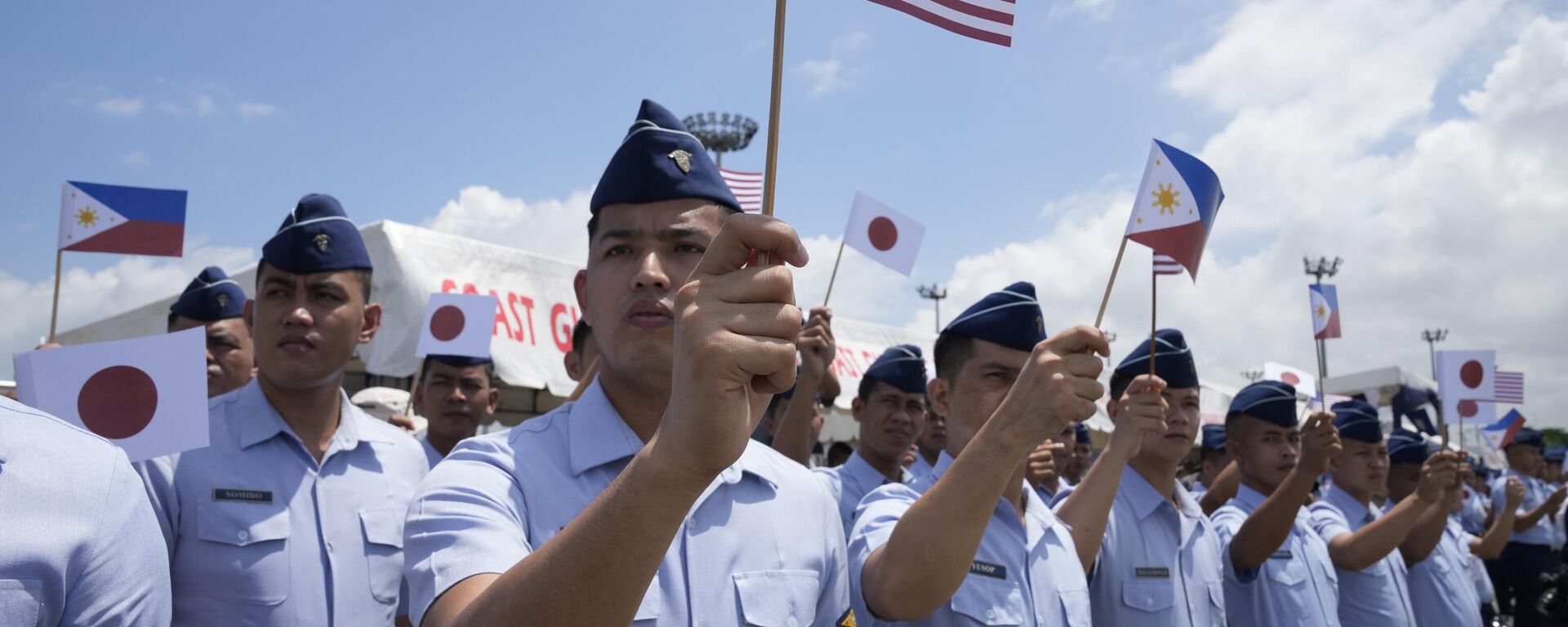 Philippine Coast Guard members wave small flags of the Philippines, U.S. and Japan during welcoming ceremonies at the pier in Manila, Philippines on Thursday, June 1, 2023 - Sputnik International, 1920, 27.04.2024