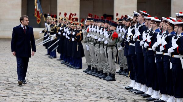French President Emmanuel Macron reviews troops during a Prise d'armes military ceremony in the courtyard of the Hotel National des Invalides in Paris, on February 19, 2024.  - Sputnik International