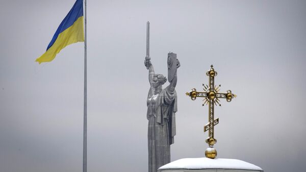 The cross of the Kiev-Pechersk Lavra monastery complex against the background of the Ukrainian national flag and the Motherland monument in Kiev. - Sputnik International