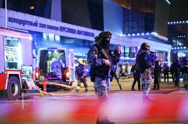 Police and firefighters working in the area of the concert hall where the deadly terrorist attack took place. - Sputnik International