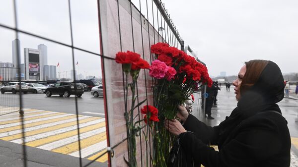 People laying flowers to commemorate the victims of the terrorist attack on the Crocus City Hall concert venue in Krasnogorsk outside Moscow, Russia. - Sputnik International