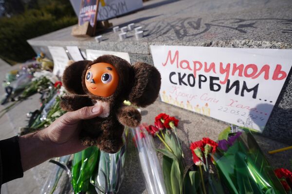 The citizens of Mariupol have erected a monument to the memory of the victims of the terrorist attack. The person in the photo is holding Cheburashka, a popular Russian character. - Sputnik International
