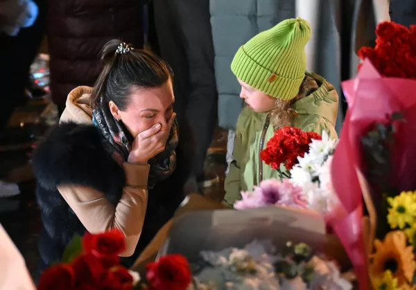 A woman and a little girl laying flowers at a memorial near Crocus City Hall.According to investigators, terrorists killed entire families with children who came to the Crocus for the concert. - Sputnik International