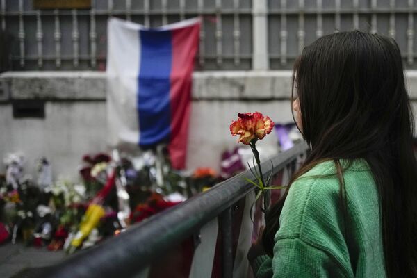 A girl holds a flower outside of the Russian Embassy in Rome.  - Sputnik International