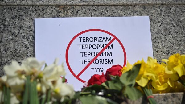 This photograph taken on March 23, 2024 in Belgrade shows a sign reading terrorism and flowers, a day after a gun attack in Krasnogorsk, outside Moscow - Sputnik International