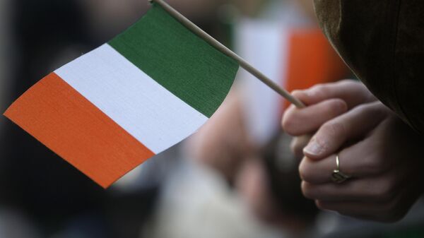A reveler holds an Irish flag while attending the St. Patrick's Day Parade Tuesday, March 17, 2009  in New York. - Sputnik International
