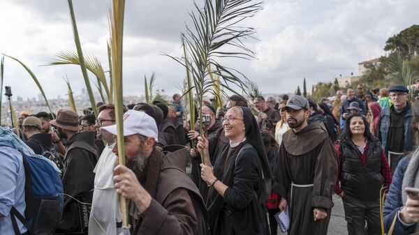 Christians walk in the Palm Sunday procession on the Mount of Olives in east Jerusalem, Sunday, March 24, 2024. (AP Photo/Ohad Zwigenberg) - Sputnik International