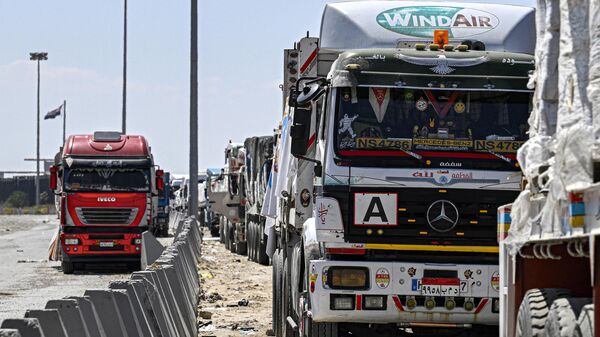 Egyptian trucks carrying humanitarian aid bound for the Gaza Strip queue outside the Rafah border crossing on the Egyptian side on March 23, 2024. - Sputnik International