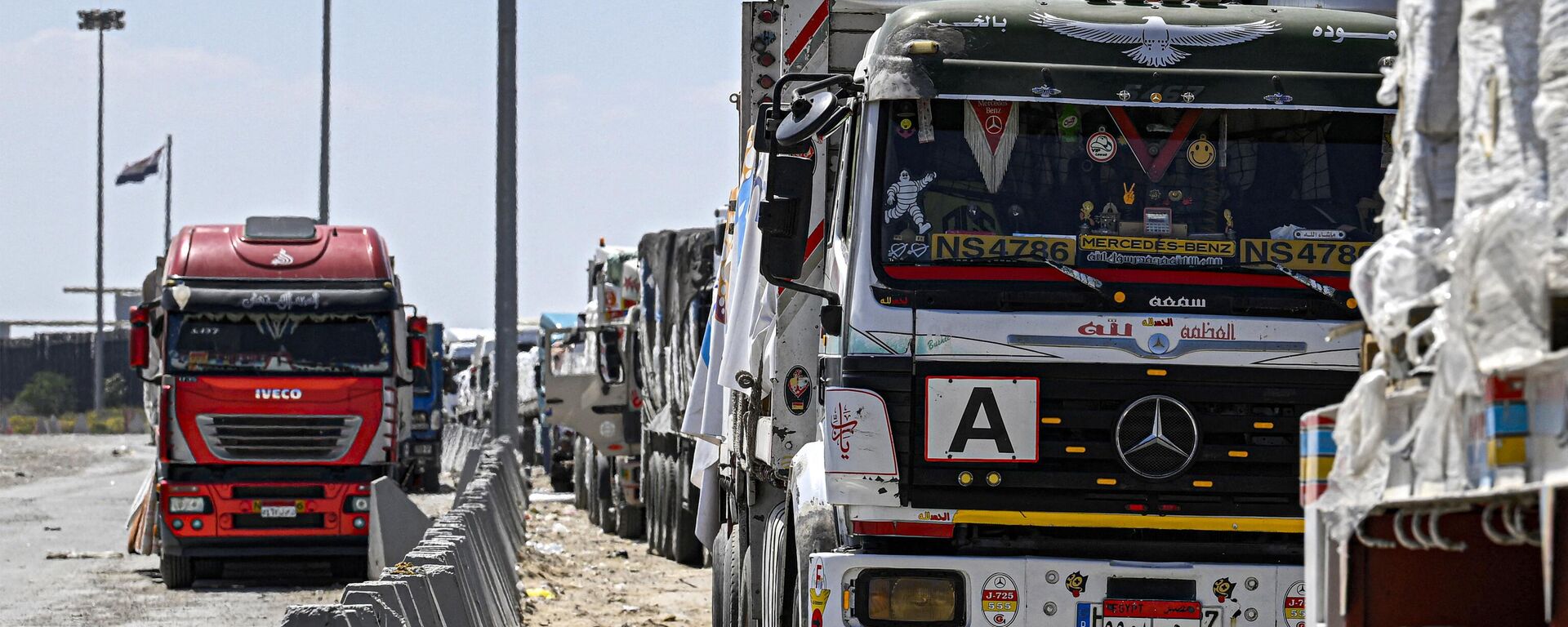 Egyptian trucks carrying humanitarian aid bound for the Gaza Strip queue outside the Rafah border crossing on the Egyptian side on March 23, 2024. - Sputnik International, 1920, 25.03.2024