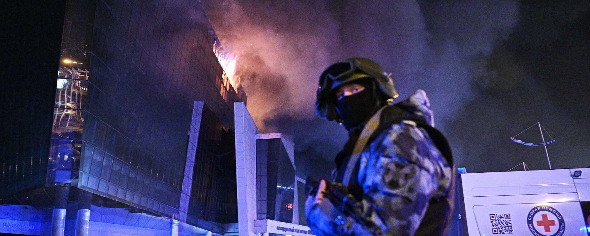 A law enforcement officer is seen near the burning Crocus City Hall concert venue following a reported shooting incident, near Moscow, Russia. - Sputnik International, 1920, 09.04.2024