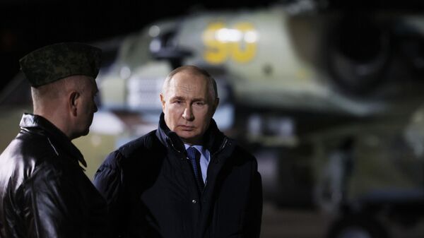 Russian President Vladimir Putin visits the State Centre for Deployment and Retraining of Flight Personnel of the Russian Defence Ministry in Torzhok, Tver region, Russia. Hero of Russia, head of aerial weapons training and tactical training of the centre, Alexander Karamyshev, is on the left. - Sputnik International