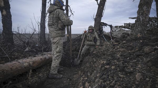 Ukrainian soldiers dig a trench on the front-line, Monday, March 18, 2024 - Sputnik International