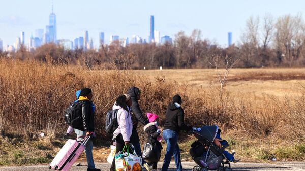 Migrants who arrived a few days ago from Eagle Pass, Texas, walk along Floyd Bennett Field in the borough of Brooklyn, New York on February 3, 2024. - Sputnik International