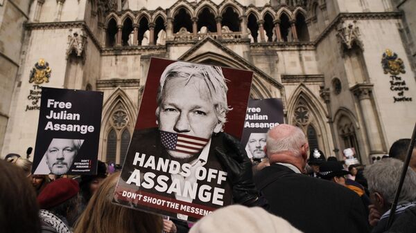 Demonstrators hold placards after Stella Assange, wife of Wikileaks founder Julian Assange, released a statement outside the Royal Courts of Justice, in London, Tuesday, March 26, 2024 - Sputnik International