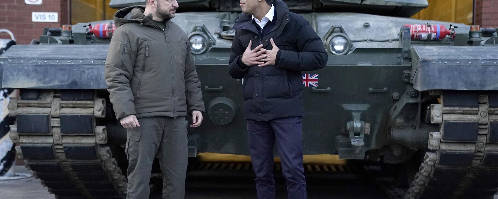 Ukraine's President Volodymyr Zelensky (L) listens to Britain's Prime Minister Rishi Sunak as they wait to meet Ukrainian troops being trained to command Challenger 2 tanks at a military facility in Lulworth, Dorset in southern England on February 8, 2023.  - Sputnik International, 1920, 29.03.2024