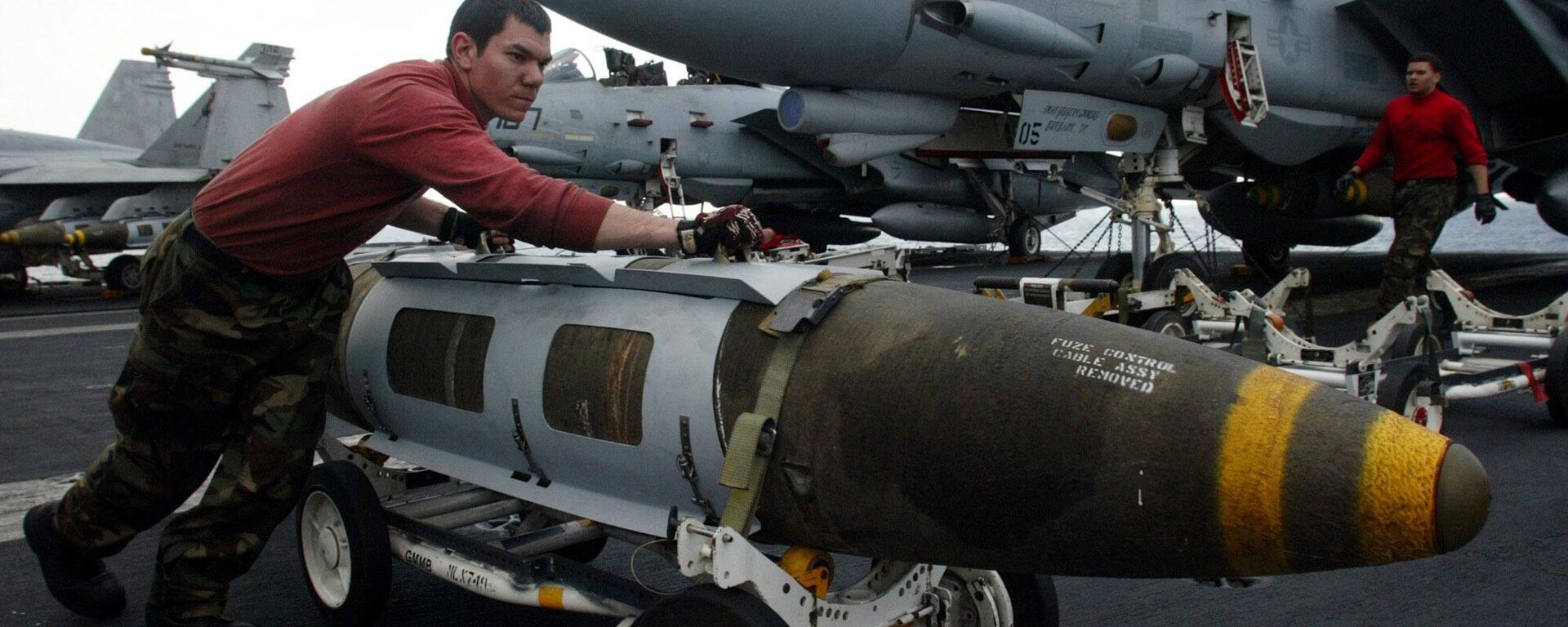 An Ordnance pushes a satellite-guided 2000 pound JDAM ( Joint Direct Attac Munitions)  bomb in front of a F-14 Tomcat on the flight deck of the USS Harry S. Truman prior to a strike against Iraq Friday, March 21, 2003 - Sputnik International, 1920, 09.05.2024