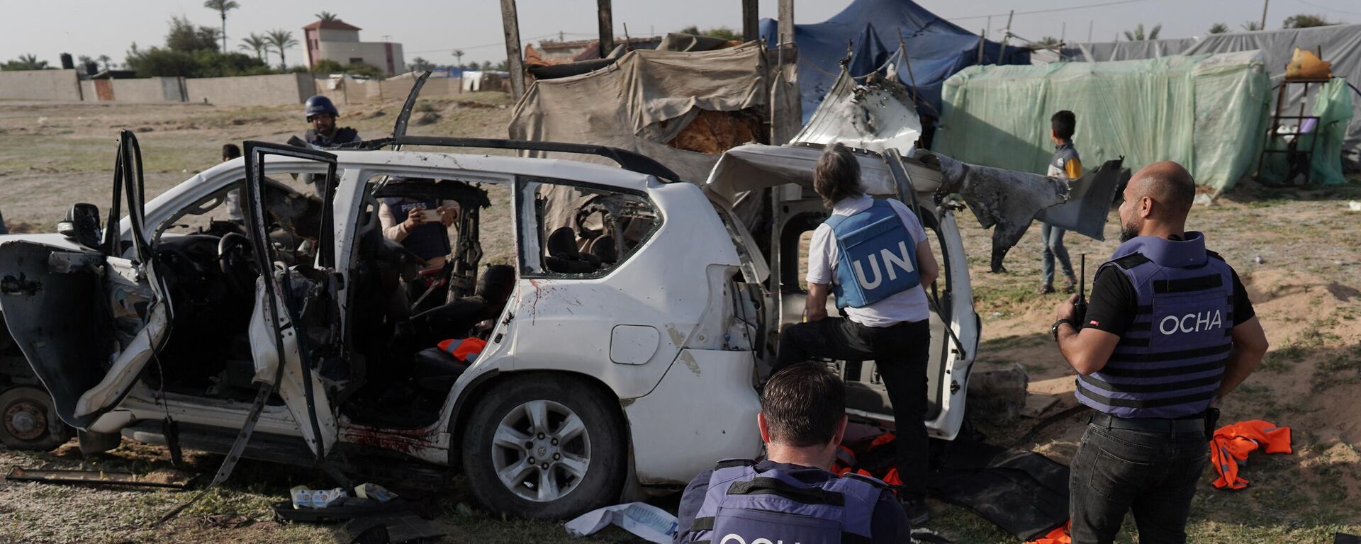 United Nations staff members inspect the carcass of a car used by US-based aid group World Central Kitchen, that was hit by an Israeli strike the previous day in Deir al-Balah in the central Gaza Strip on April 2, 2024. - Sputnik International, 1920, 04.04.2024