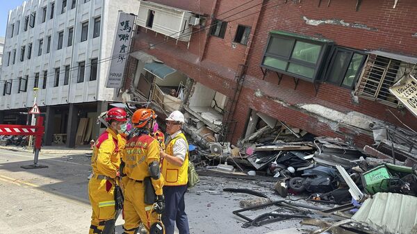 Members of a search and rescue team prepare outside a leaning building in the aftermath of an earthquake in Hualien, eastern Taiwan. - Sputnik International