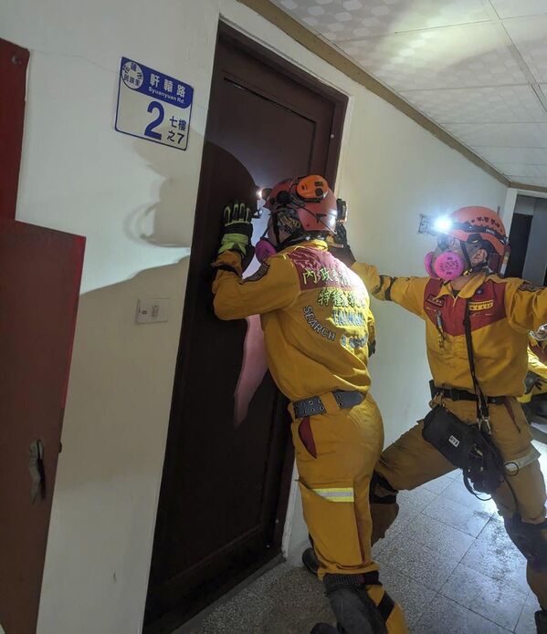 Members of a search and rescue team look for victims inside a leaning building in the aftermath of an earthquake in Hualien, eastern Taiwan.  - Sputnik International