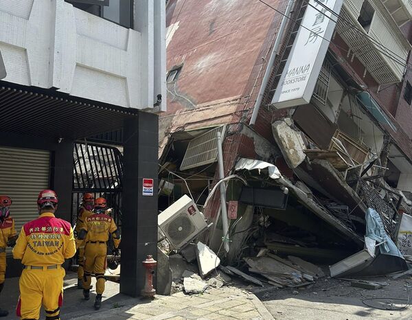 In this photo released by the National Fire Agency, members of a search and rescue team prepare outside a leaning building in the aftermath of an earthquake in Hualien, eastern Taiwan. - Sputnik International