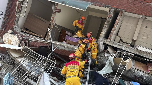 Члены поисково-спасательной команды возле разрушенного здания после землетрясения в Хуаляне, восточный Тайвань, Китай - Sputnik International