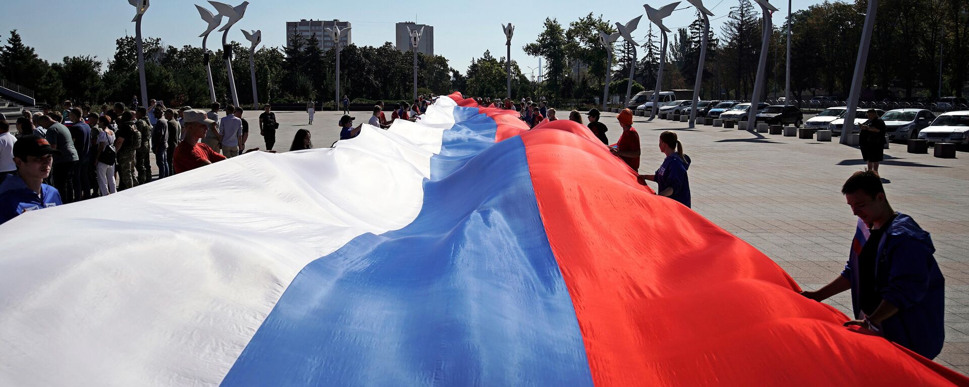 People hold a giant Russian flag during celebrations of the Russia's National Flag Day - Sputnik International, 1920, 03.04.2024