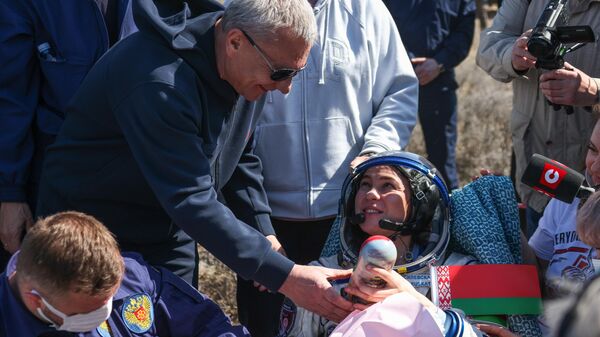 Yury Borisov, Director General of the Federal Space Agency Roscosmos, presents Marina Vasilevskaya, a member of the 21st Expedition to the ISS from Belarus, with a matryoshka doll bearing her picture near the descent vehicle of the Soyuz MS-24 manned spacecraft. - Sputnik International