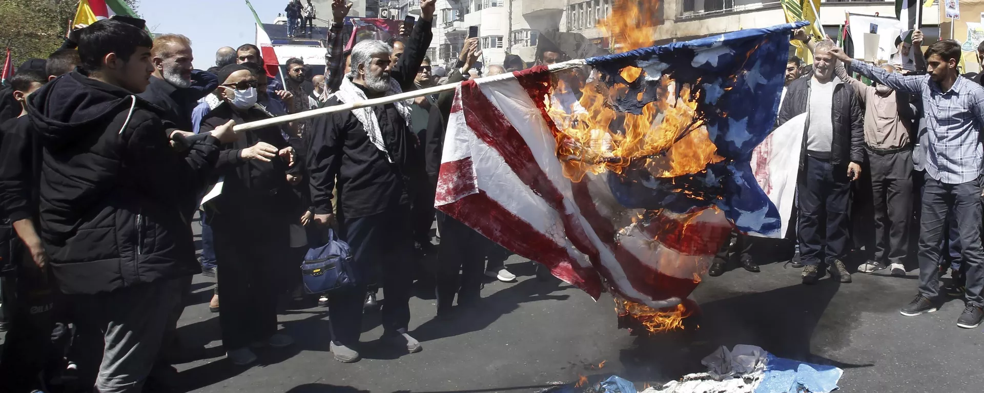 Iranian demonstrators burn representations of the US and Israeli flags during an annual rally to mark Quds Day, or Jerusalem Day, in support of Palestinians, in Tehran, Iran, Friday, April 5, 2024. In the rally in Tehran, thousands attended a funeral procession for the seven Revolutionary Guard members killed in an airstrike widely attributed to Israel that destroyed Iran's Consulate in the Syrian capital on Monday. (AP Photo/Vahid Salemi) - Sputnik International, 1920, 28.10.2024