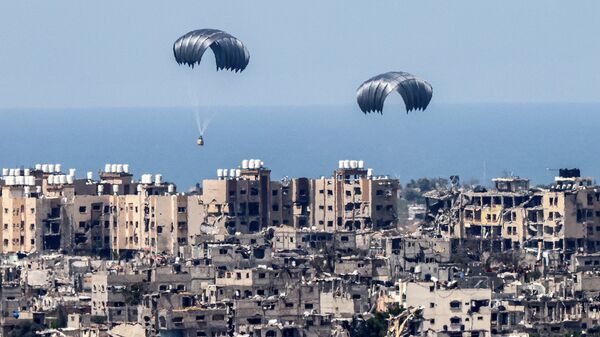 This picture taken from Israel's southern border with the Gaza Strip shows parachutes of humanitarian aid dropping over the besieged Palestinian territory on March 26, 2024, amid the ongoing conflict between Israel and the militant group Hamas. - Sputnik International