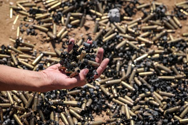 A person holds a handful of spent bullet casings above a bigger pile in Khan Yunis - Sputnik International