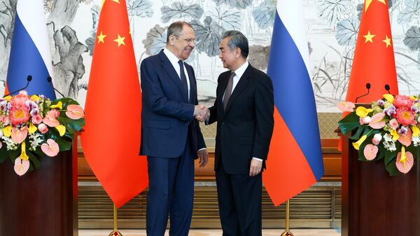 Russian Foreign Minister Sergey Lavrov and Chinese Foreign Minister Wang Yi shake hands during a joint press conference following their meeting at the Diaoyutai State Guest House in Beijing, China - Sputnik International