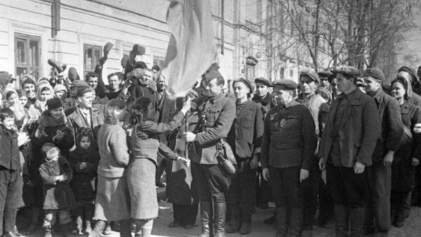 Odessa residents O. Polak and O. Klefortova handing the Red Banner over to the partisan detachment that entered the city. Locals kept the banner throughout the entire Nazi occupation - Sputnik International