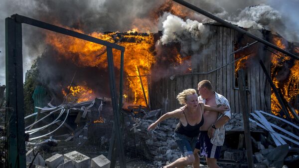 Local residents flee a fire caused by an air strike of the Ukrainian armed forces on a settlement in Lugansk region in 2014. - Sputnik International