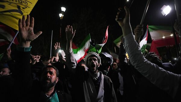 Iranian demonstrators chant slogans during an anti-Israeli gathering in front of the British Embassy in Tehran, Iran, early Sunday, April 14, 2024. Iran launched its first direct military attack against Israel on Saturday. - Sputnik International
