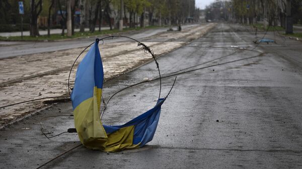 A Ukrainian national flag on a wire on the ground in the Russian city of Mariupol, April 18, 2022 - Sputnik International