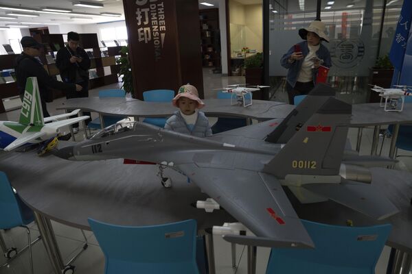 A child stands near a model of a Chinese aircraft fighter jet at the People&#x27;s Liberation Army’s (PLA) naval submarine academy. - Sputnik International